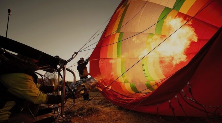 Flame inflating a hot air balloon at sunrise in Cafayate – Wine Tours in Style experience.