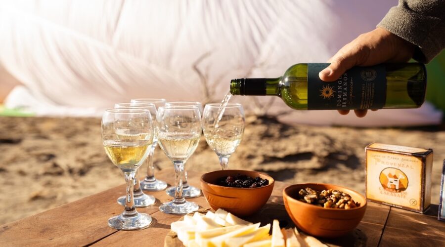 Glasses of white wine being served with local cheese and nuts after a hot air balloon landing in Cafayate, Argentina’s high-altitude wine region.