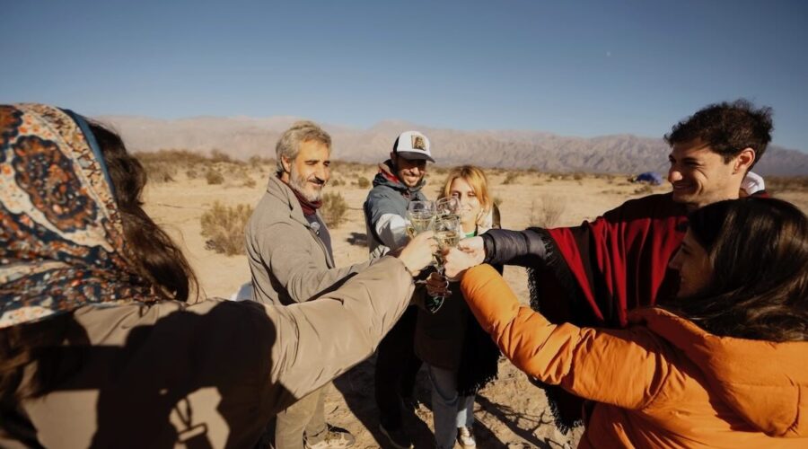 Group toasting with white wine after a hot air balloon experience in Cafayate, organized by Wine Tours in Style.